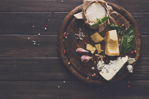 Kaas delikatessen op rustieke hout, blauwe roquefort, brie en Parmezaanse kaas — Stockfoto