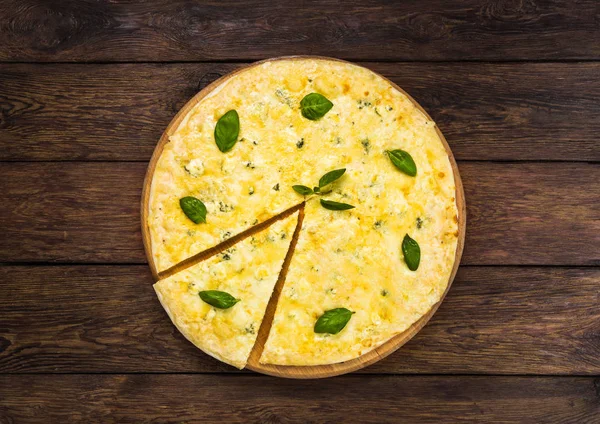 Delicious four cheese pizza with basil leaves