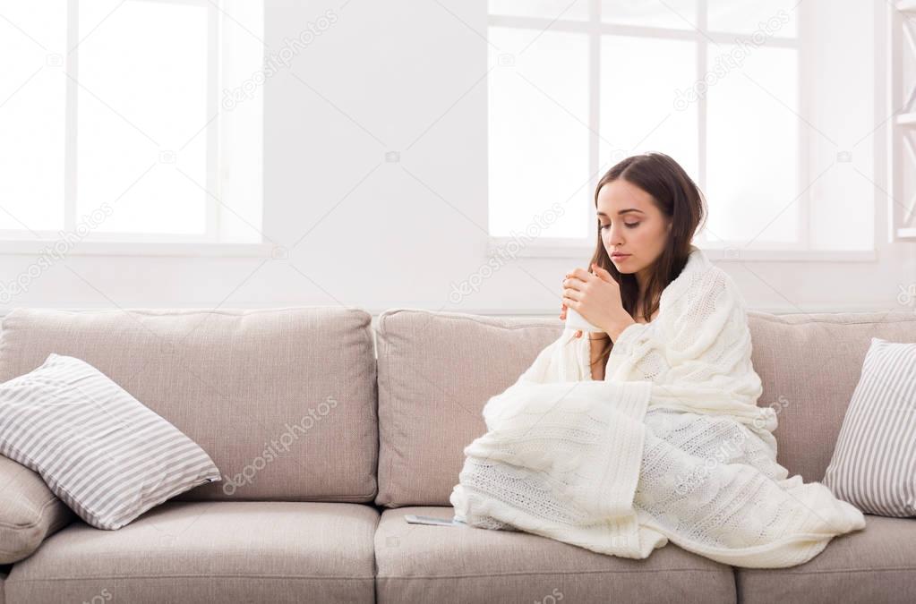 Cozy home. Girl in a plaid on the couch