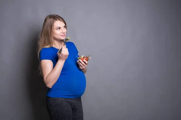 Wanita hamil muda makan salad hijau segar — Stok Foto
