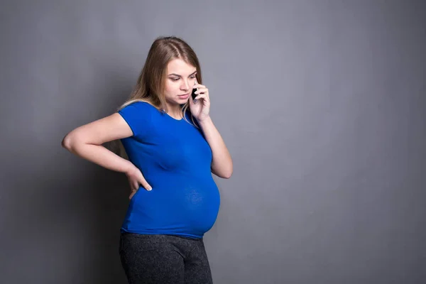 Inquiète femme enceinte parler sur l'espace de copie de téléphone — Photo