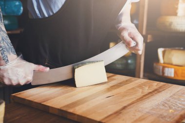 Bakkal dükkanında sert peynir kesme