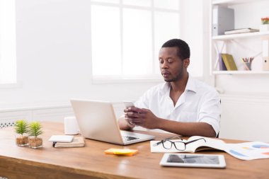 Dizüstü bilgisayarda çalışırken telefonu genç Afrikalı-Amerikalı işadamı manifatura