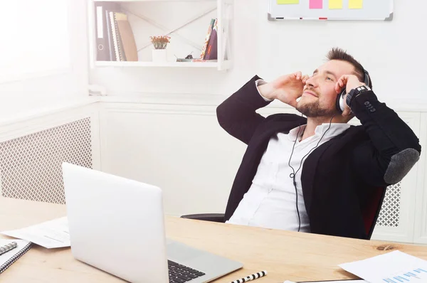 Ung avslappnad affärsman lyssna musik i moderna vita office — Stockfoto