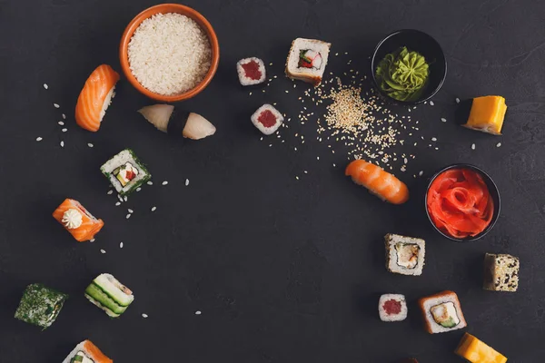 Sushi en rollen achtergrond, frame op zwart, top uitzicht. — Stockfoto