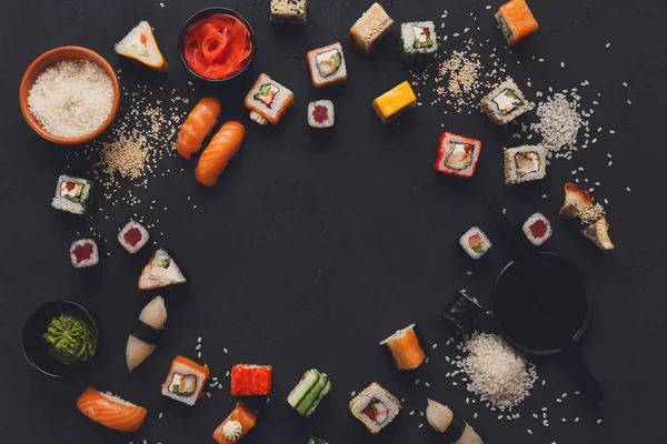 Sushi e rotoli di sfondo, cornice su nero, vista dall'alto . — Foto Stock