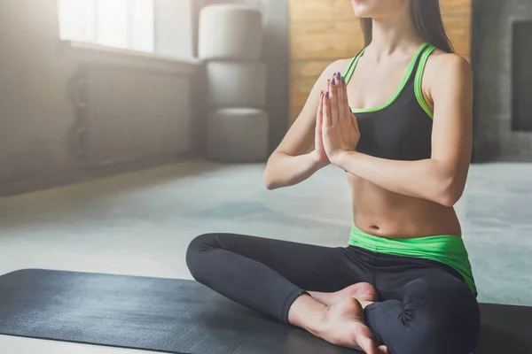 Jonge aantrekkelijke vrouw beoefenen van yoga zitten in padmasana — Stockfoto