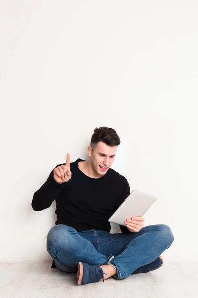 Estudiante masculino estudio en línea, sentarse con el ordenador portátil, apuntando hacia arriba — Foto de Stock