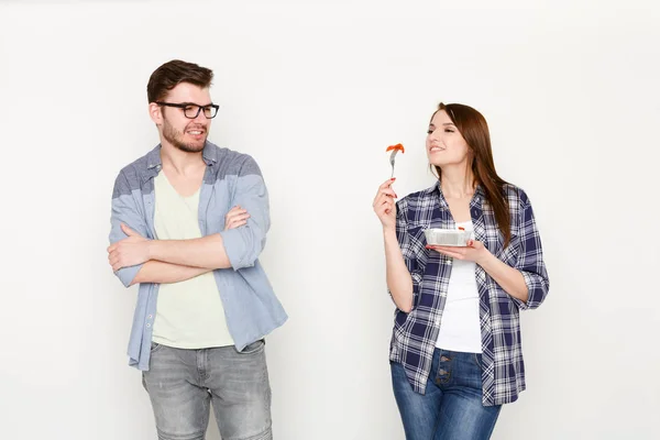 Pareja en casual en blanco aislado fondo, comer alimentos saludables — Foto de Stock