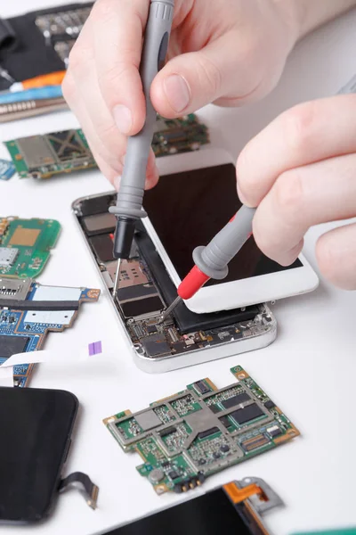 Repareren van smartphone met multimeter close-up — Stockfoto