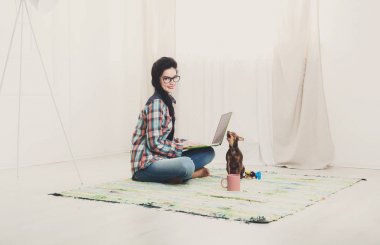 Dizüstü bilgisayar ve köpek katta genç kız