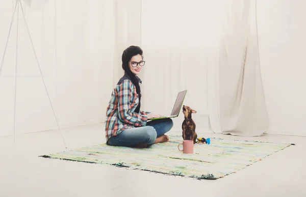 Junges Mädchen auf dem Boden mit Laptop und Hund — Stockfoto