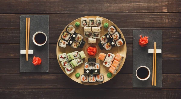 Set of sushi maki and rolls on black rustic wood, top view — Stock Photo, Image