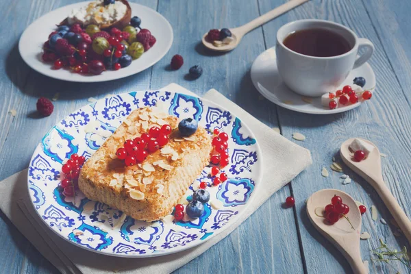 Pastry pie, tea and berries at blue rustic wood