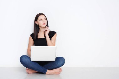 Stüdyo katta oturan dizüstü kullanan kadın