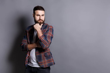 Dalgın sakallı hippi adam çene üzerinde el ile