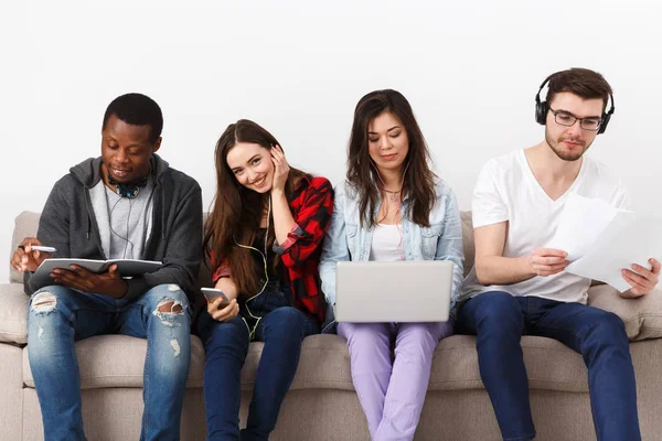 Jóvenes diversos escuchan música con gadgets — Foto de Stock