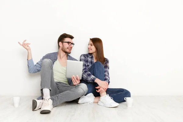 Pareja casual discutir algo sentado con la tableta, toma de estudio — Foto de Stock