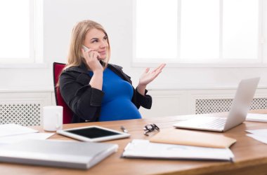 Hamile iş kadını telefonda konuşurken iş başında