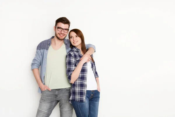 Couple souriant dans un étreinte décontractée sur fond de studio blanc, isolé — Photo