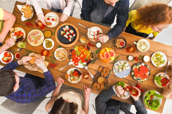 Mensen eten gezonde maaltijden op tafel geserveerd diner — Stockfoto