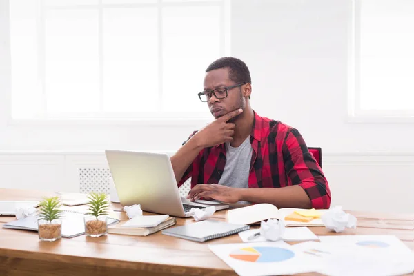 Στοχαστικός μαύρο επιχειρηματία σε casual γραφείο, εργασία με φορητό υπολογιστή — Φωτογραφία Αρχείου