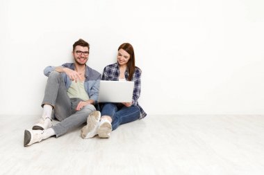 Gülümseyen çift web-sörf üstünde laptop, stüdyo vurdu