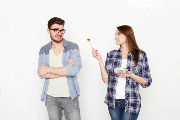 Pareja en casual en blanco aislado fondo, comer alimentos saludables — Foto de Stock