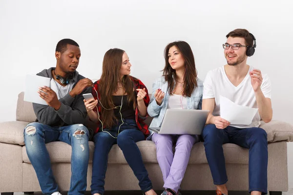 Young diverse people listen to music with gadgets