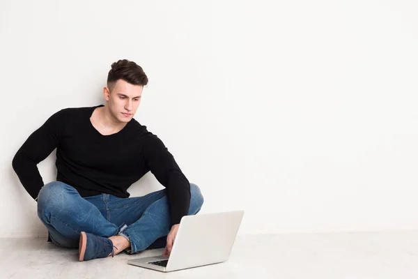 Jongeman freelancer in casual met laptop — Stockfoto