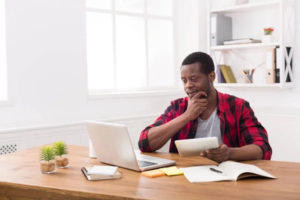 Biznesmen w biurze na co dzień z czarnym, działa zarówno na tablecie i laptopie — Zdjęcie stockowe