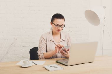Orta yaşlı iş kadını içinde yazıhane telefon ile
