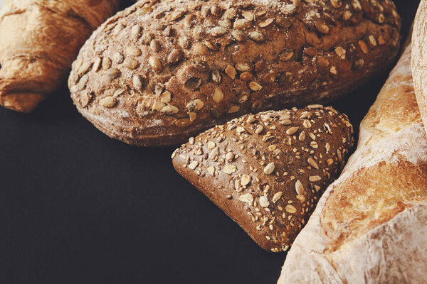 Bread assortment on black background with copy space