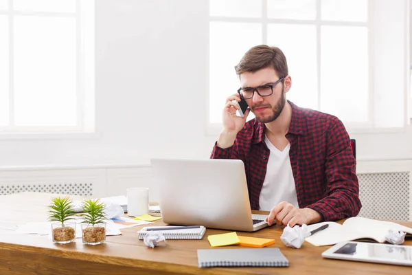 Junger konzentrierter Geschäftsmann liest Dokumente in modernem weißen Büro — Stockfoto