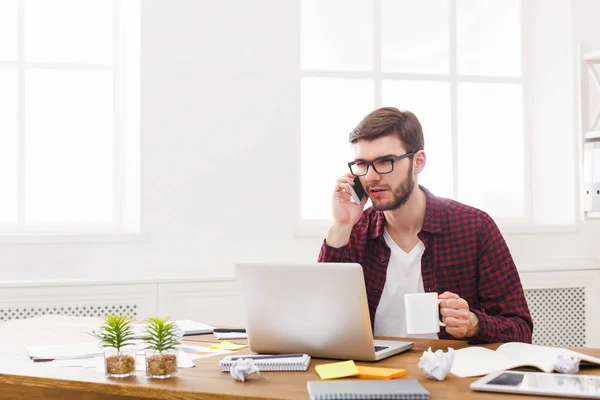 Joven empresario serio con portátil en la oficina blanca moderna — Foto de Stock