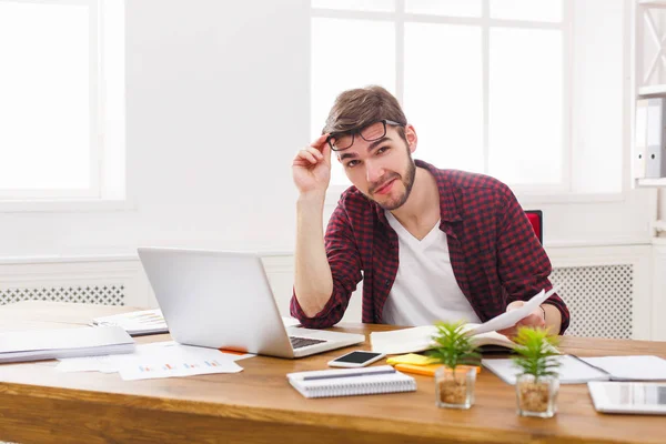 Молодой расслабленный бизнесмен с ноутбуком в современном белом офисе — стоковое фото