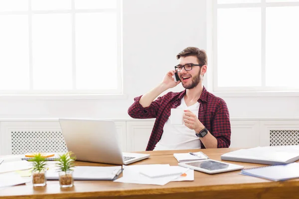 Unga nöjda affärsman har en mobil prat i modern vit kontor — Stockfoto