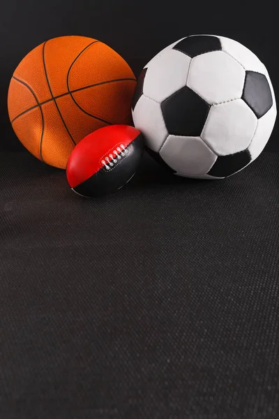 Assorted sport balls on black background