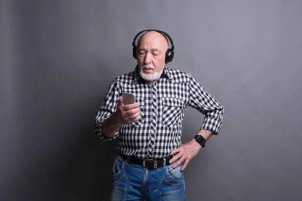 Homem sênior ouvindo música com fones de ouvido — Fotografia de Stock