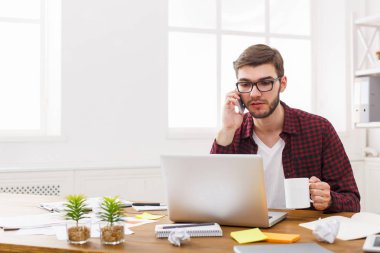 Modern beyaz ofis içinde laptop ile genç ciddi iş adamı