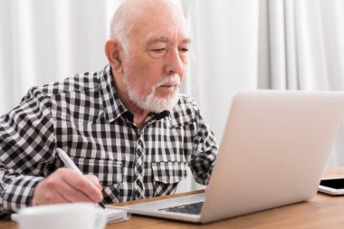 Dizüstü bilgisayar kullanma ve Not Defteri'nde yazma olgun adam