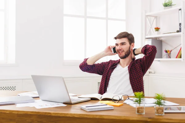 Joven hombre de negocios relajado tiene una charla móvil en la oficina blanca moderna — Foto de Stock