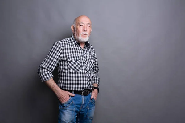 Sério homem sênior posando com as mãos nos quadris — Fotografia de Stock