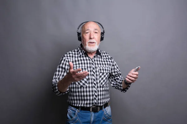 Homem sênior ouvindo música com fones de ouvido — Fotografia de Stock