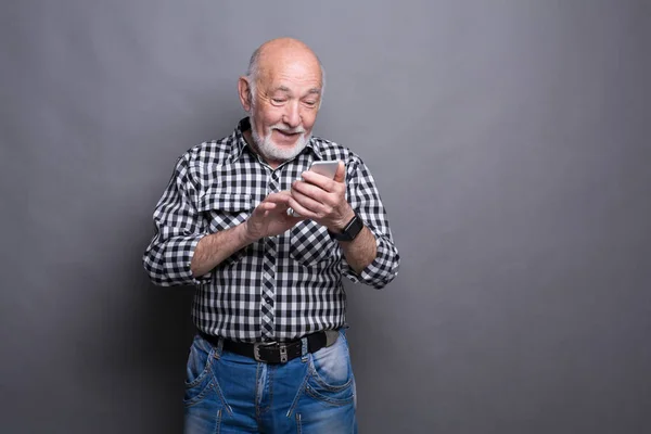 Alegre sênior homem digitando mensagem no smartphone — Fotografia de Stock