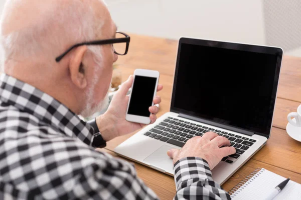 パソコンとスマート フォンのモックアップを使用して年配の男性 — ストック写真