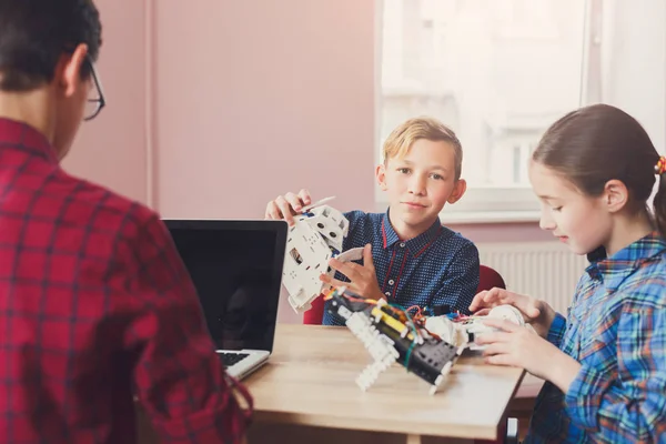 Stem education. Kids creating robots with teacher