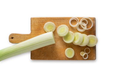 Dilimlenmiş ve doğranmış pırasa ahşap kesme tahtası üzerinde beyaz arka plan izole