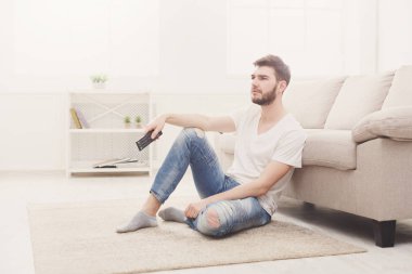 İstimal uzak murakıp oturma odasında televizyon seyretmek genç adam