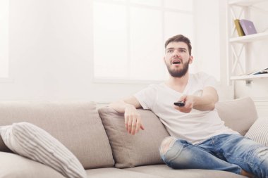 Endişeli genç adam wathing evde tv